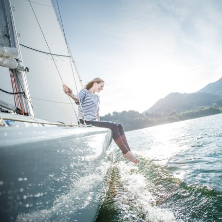 Eine junge Frau genießt das erfrischende Nass des Tegernsees beim Segeln., © Hansi Heckmair